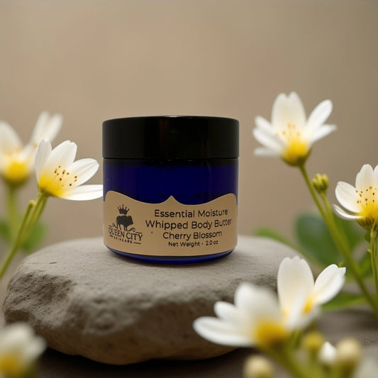 QCS Essential Moisture Cherry Blossom Whipped Body Butter in blue jar with flowers, 2 fl oz, handcrafted skincare.