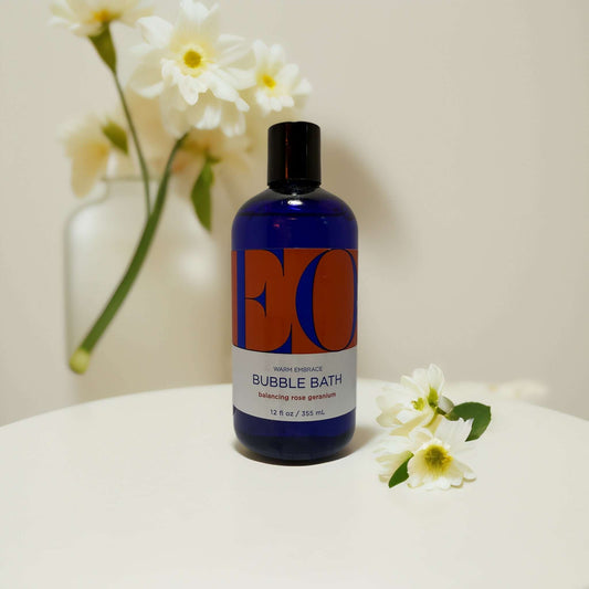 EO Bubble Bath in blue bottle with flower accents.