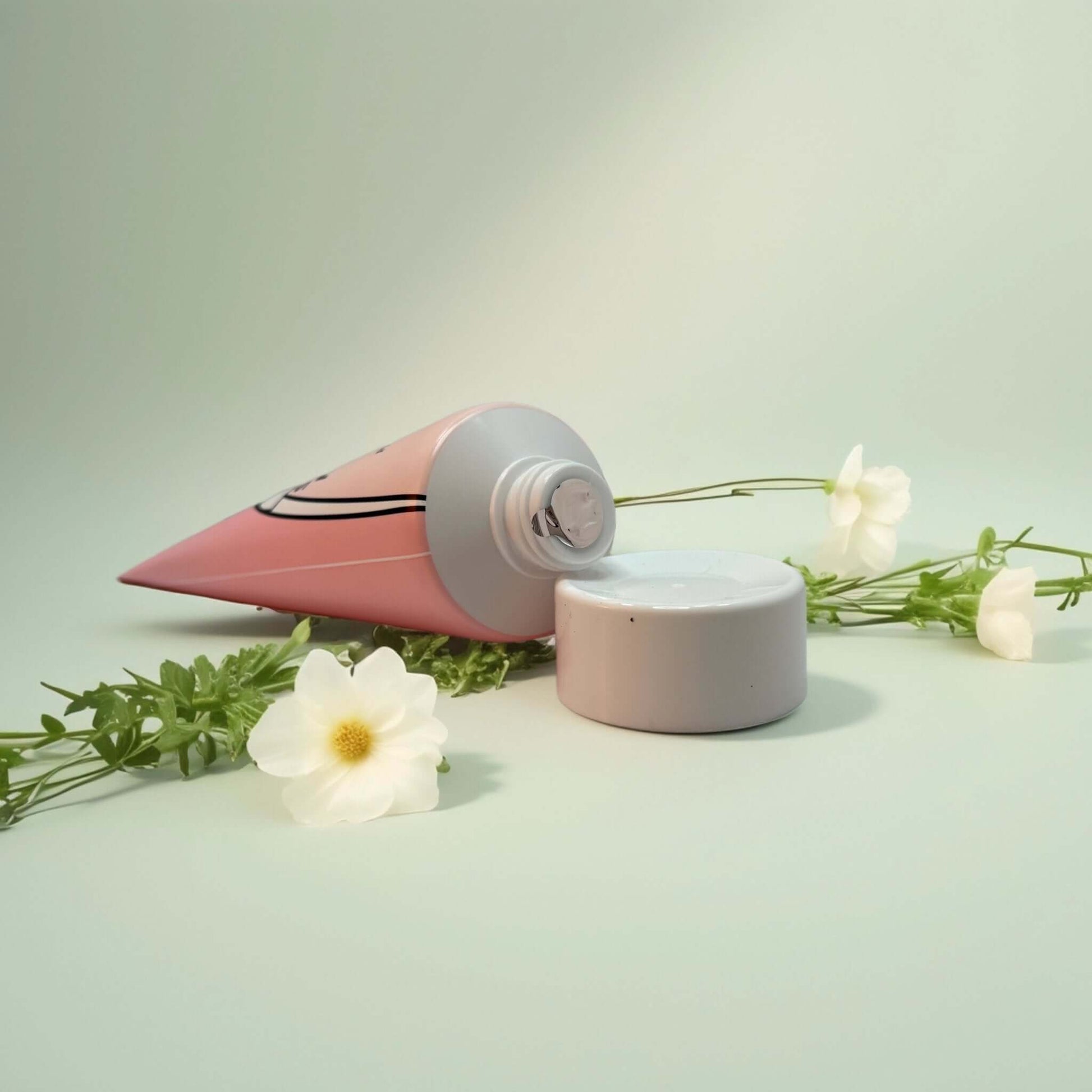 Bonnyhill Strawberry Milk Cream tube with cap, floral backdrop.