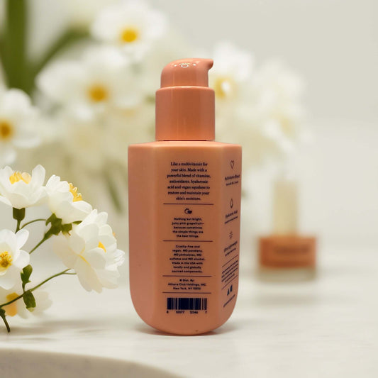 Dewy Body Lotion Grapefruit Spritz bottle with floral background.