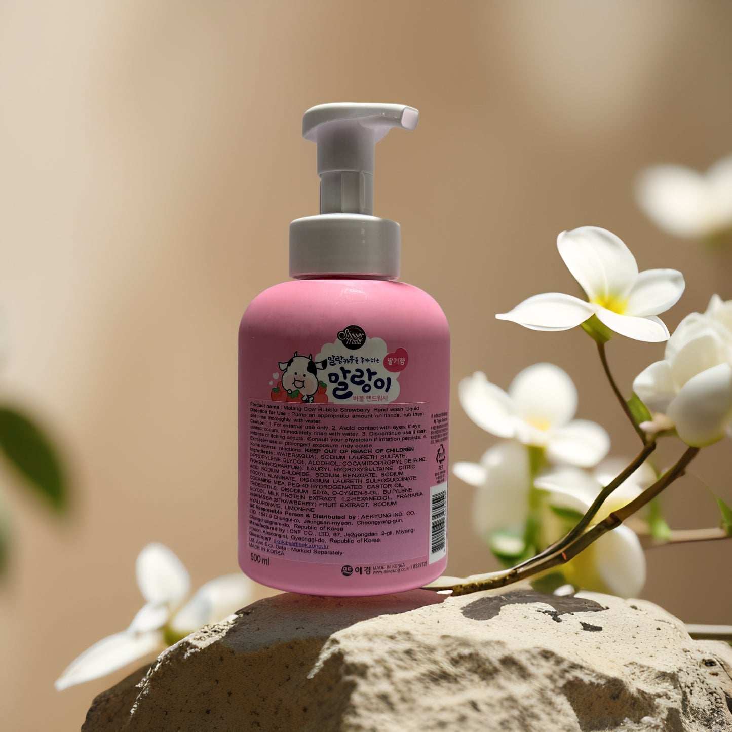 Brightening Cleanse Strawberry Bubble Hand Wash in pink pump bottle, surrounded by flowers and rocks.