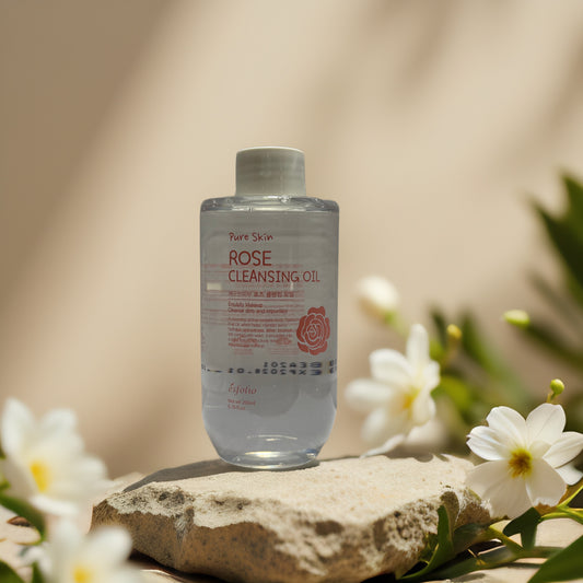 Rose Cleansing Oil by Esfolio on stone, surrounded by flowers, gently removes makeup and hydrates skin.