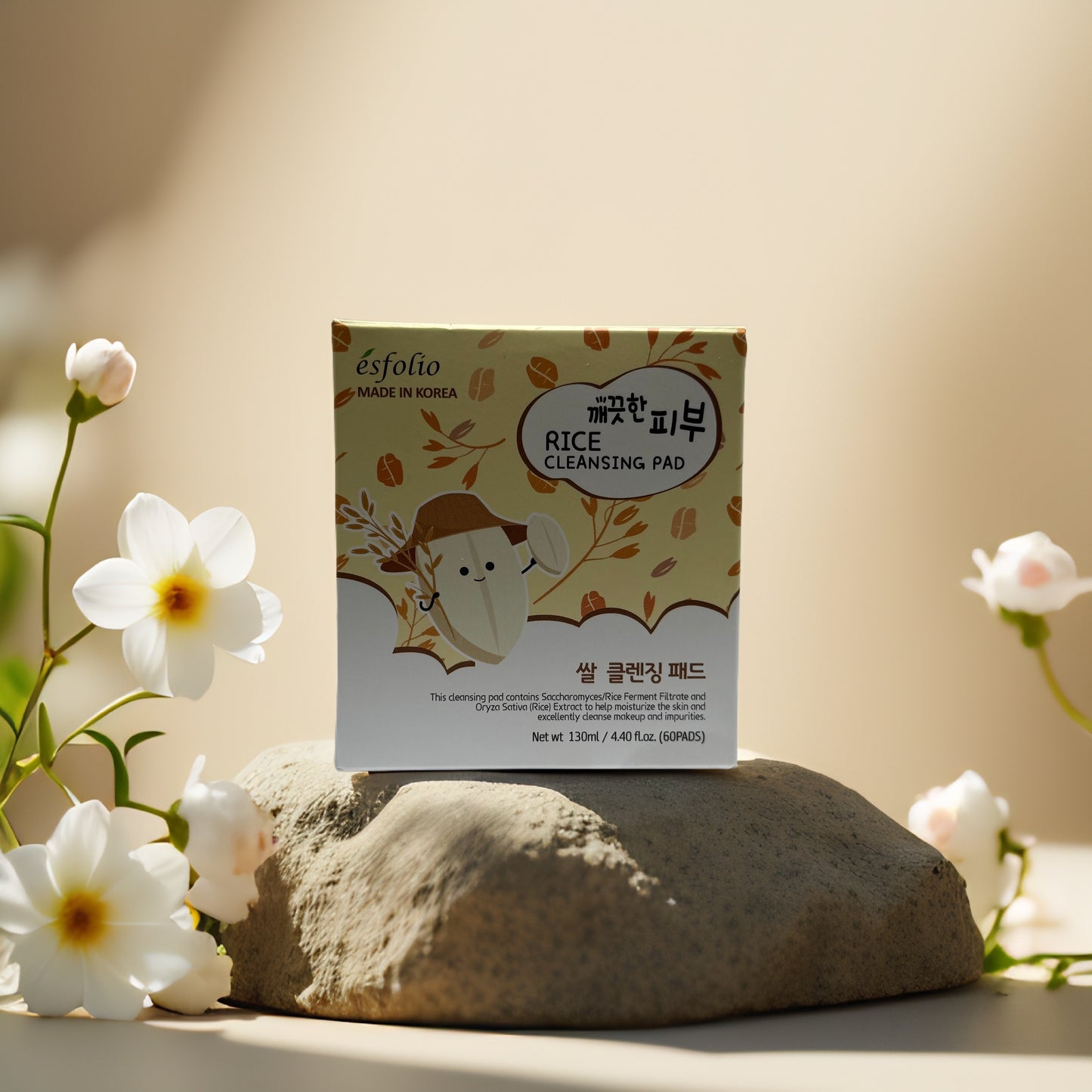 Esfolio Rice Cleansing Pad box on stone with flowers, for gentle exfoliation and brightening.