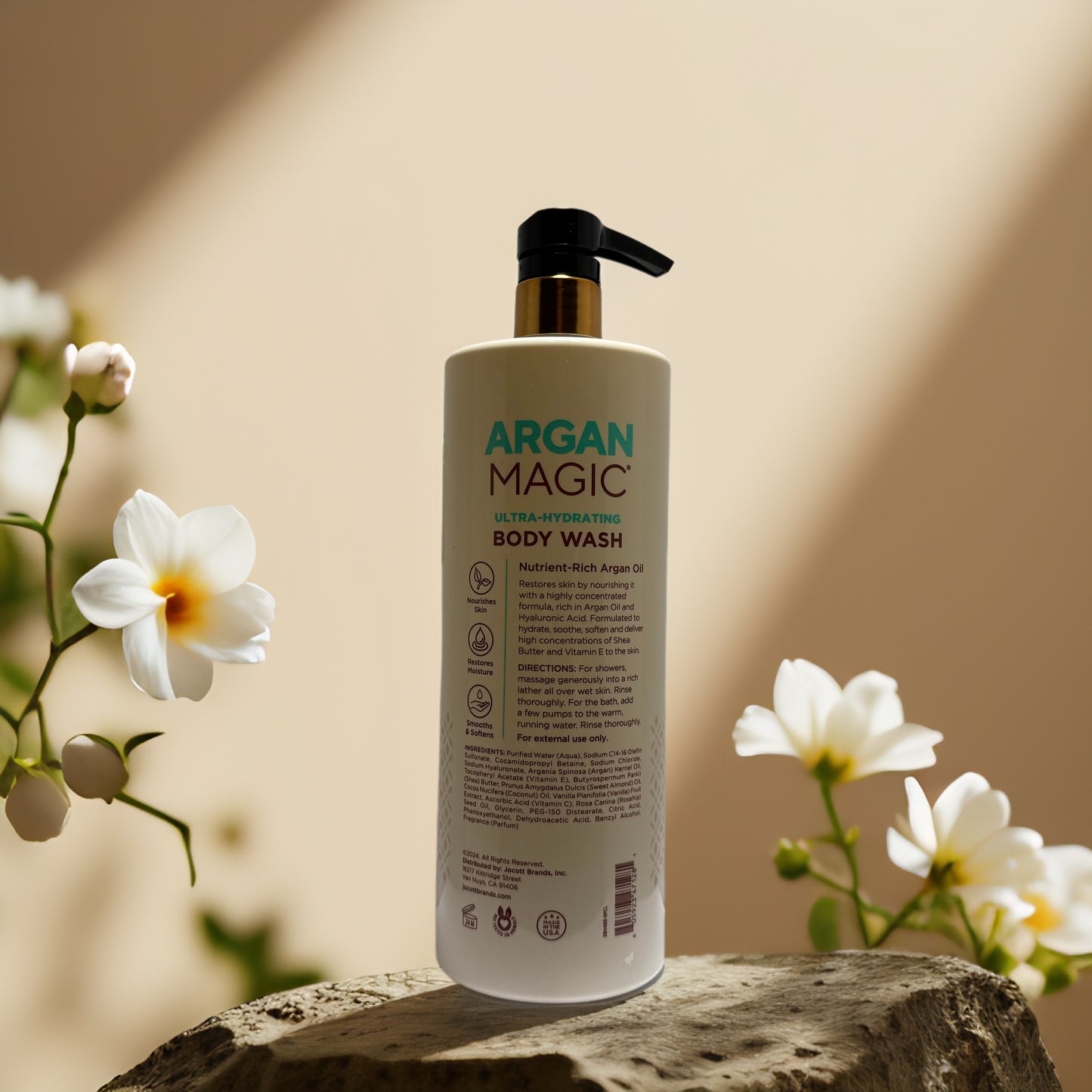 Argan Magic Ultra-Hydrating Body Wash bottle on a stone with flowers, 32 fl oz, enriched with argan oil and hyaluronic acid.