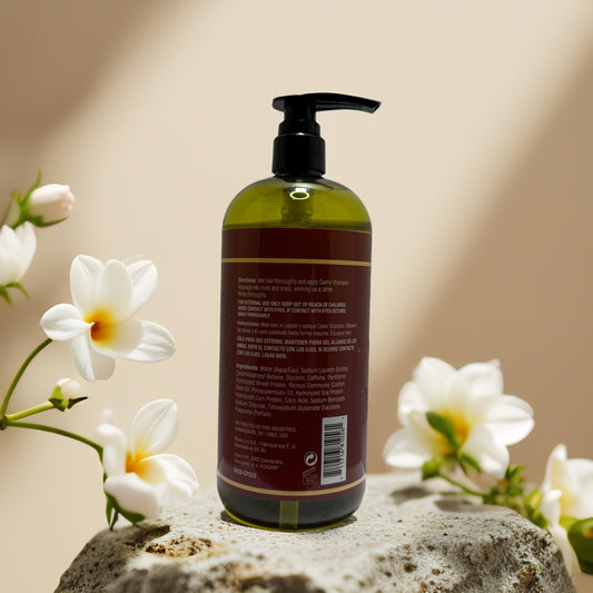 Castor Pro-Growth Shampoo bottle back view with ingredients on display, surrounded by white flowers.