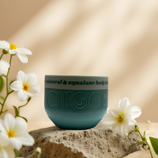 Deep Hydration & Detox Sea Mineral Body Butter by Circa Beauty in teal container with flowers.