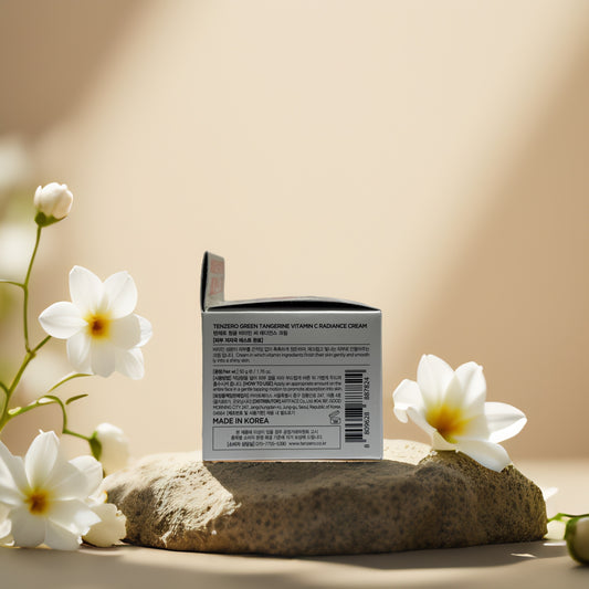 Tenzero Vitamin C Radiance Cream box with floral accents on a stone background, highlighting brightening features.