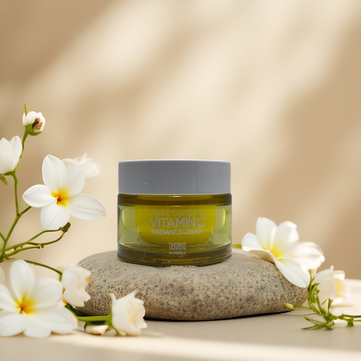 Brighten & Hydrate Vitamin C Radiance Cream by Tenzero with floral accent on a stone surface.