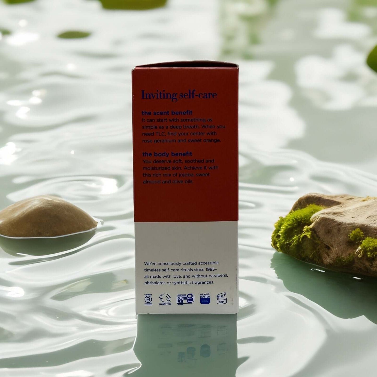 Body Boost Bath Oil Rose Geranium packaging on stone surface.