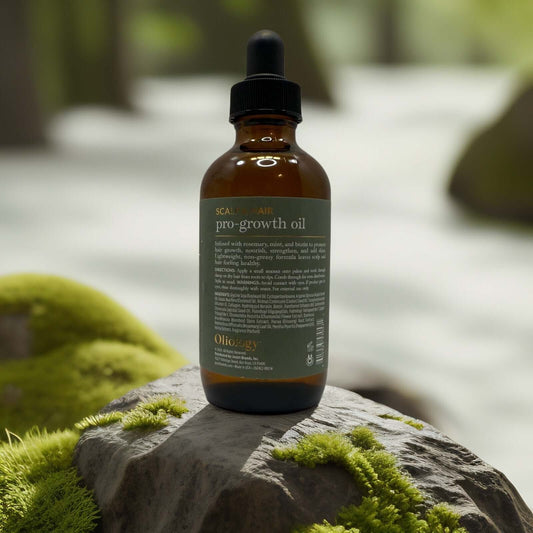 Oliology Pro-Growth Hair & Scalp Oil bottle on a mossy rock