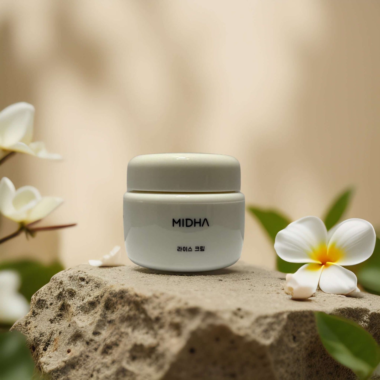 MIDHA Rice Facial Cream on stone surrounded by flowers, designed to brighten and hydrate skin.