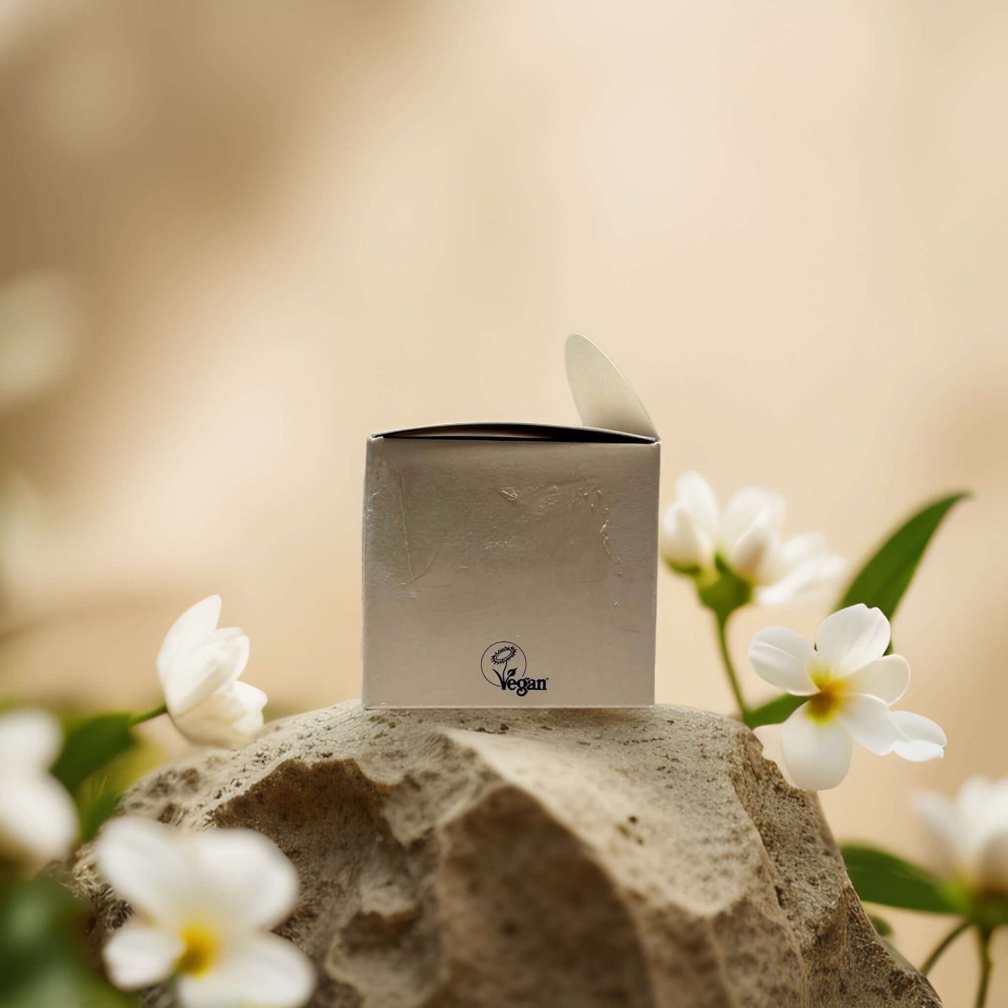 Vegan skincare box surrounded by white flowers, highlighting natural beauty and eco-friendly packaging.