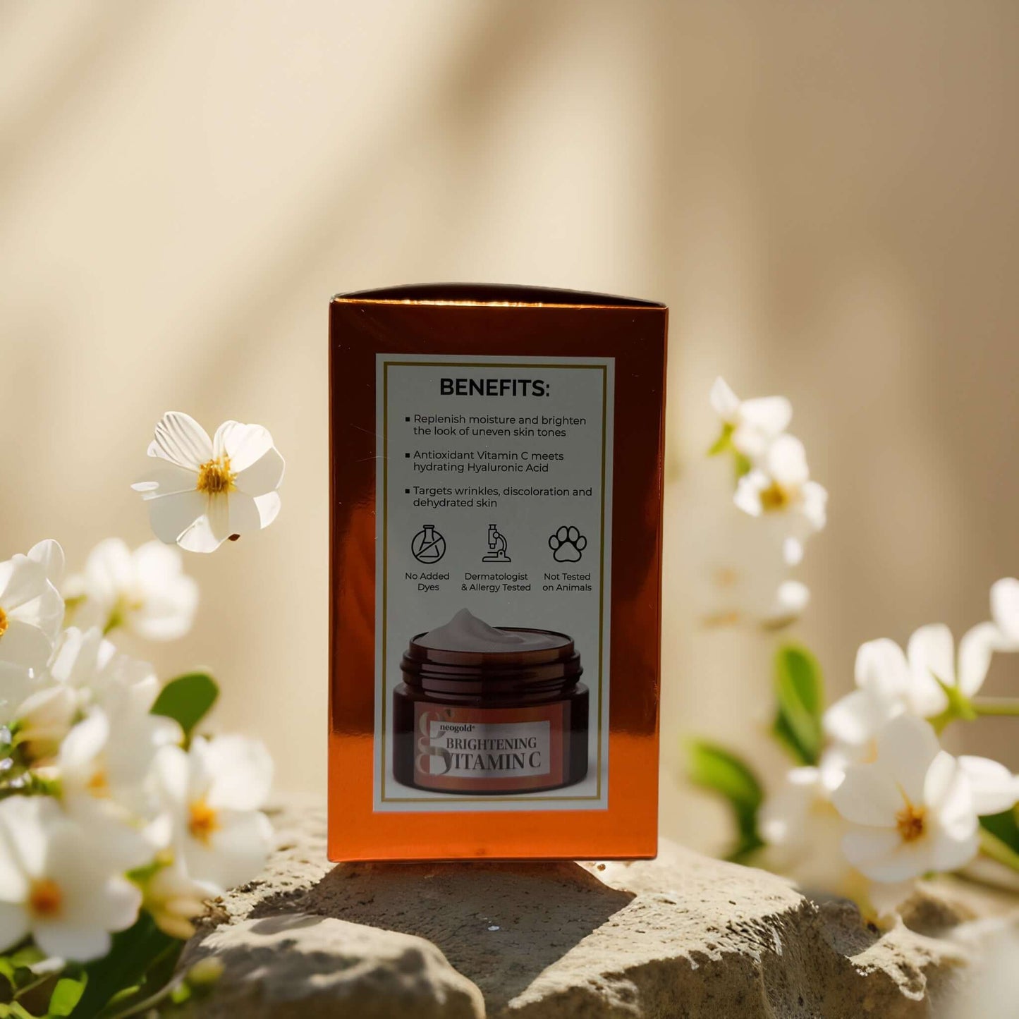 Brightening Vitamin C face cream box highlighting benefits and ingredients, surrounded by white flowers.
