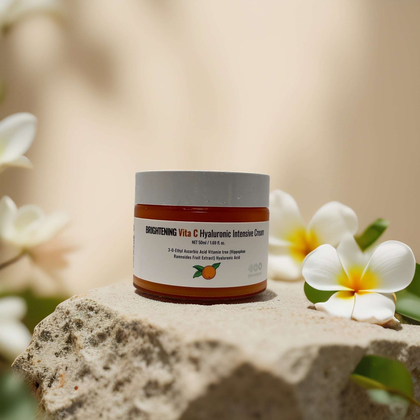 Brightening Vita C & Hyaluronic Face Cream by Dearboo in a jar on a stone surface with flowers, 1.7 fl oz.