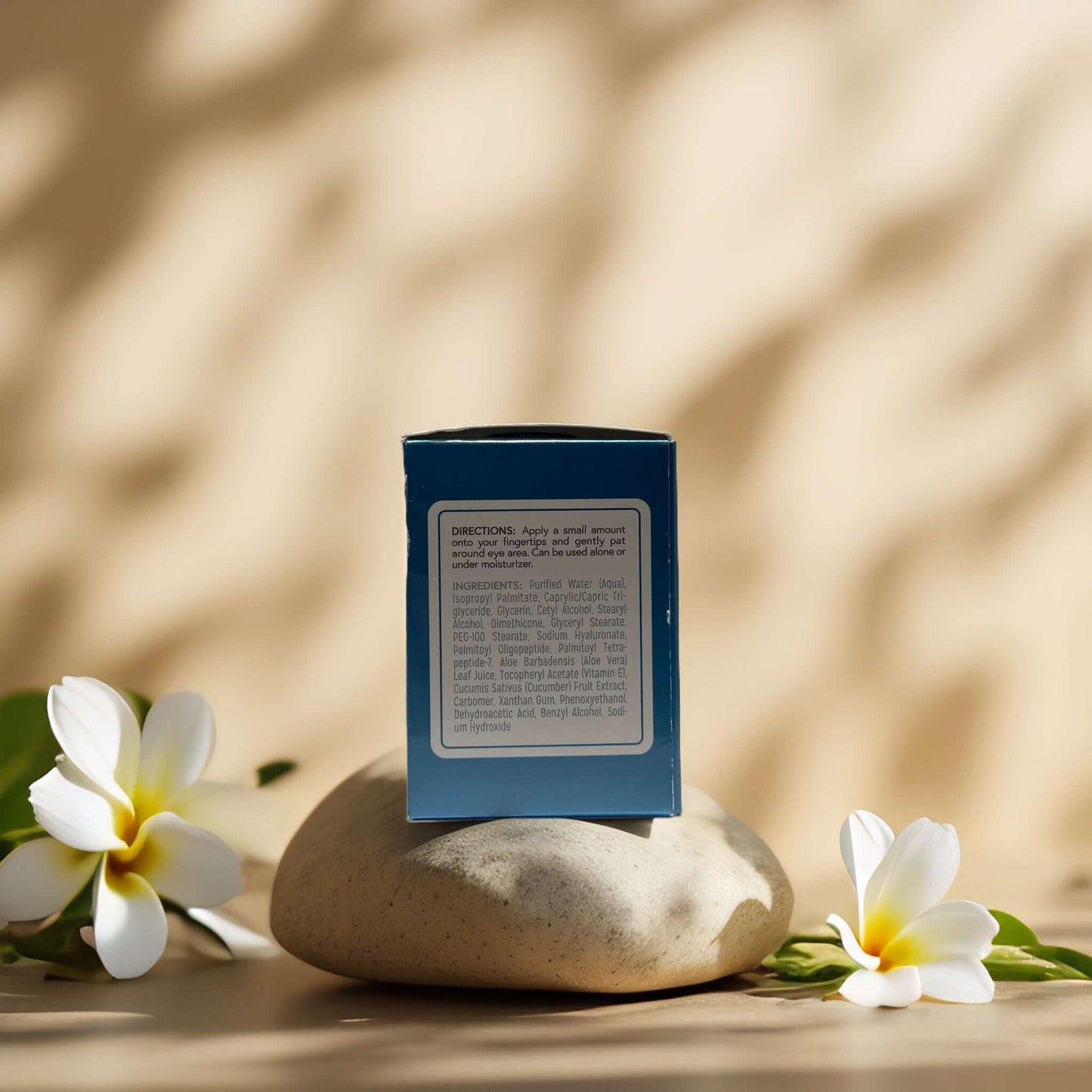 De-Puff & Hydrate Cooling Eye Gel packaging on a stone with flowers, emphasizing hydration and refreshment.