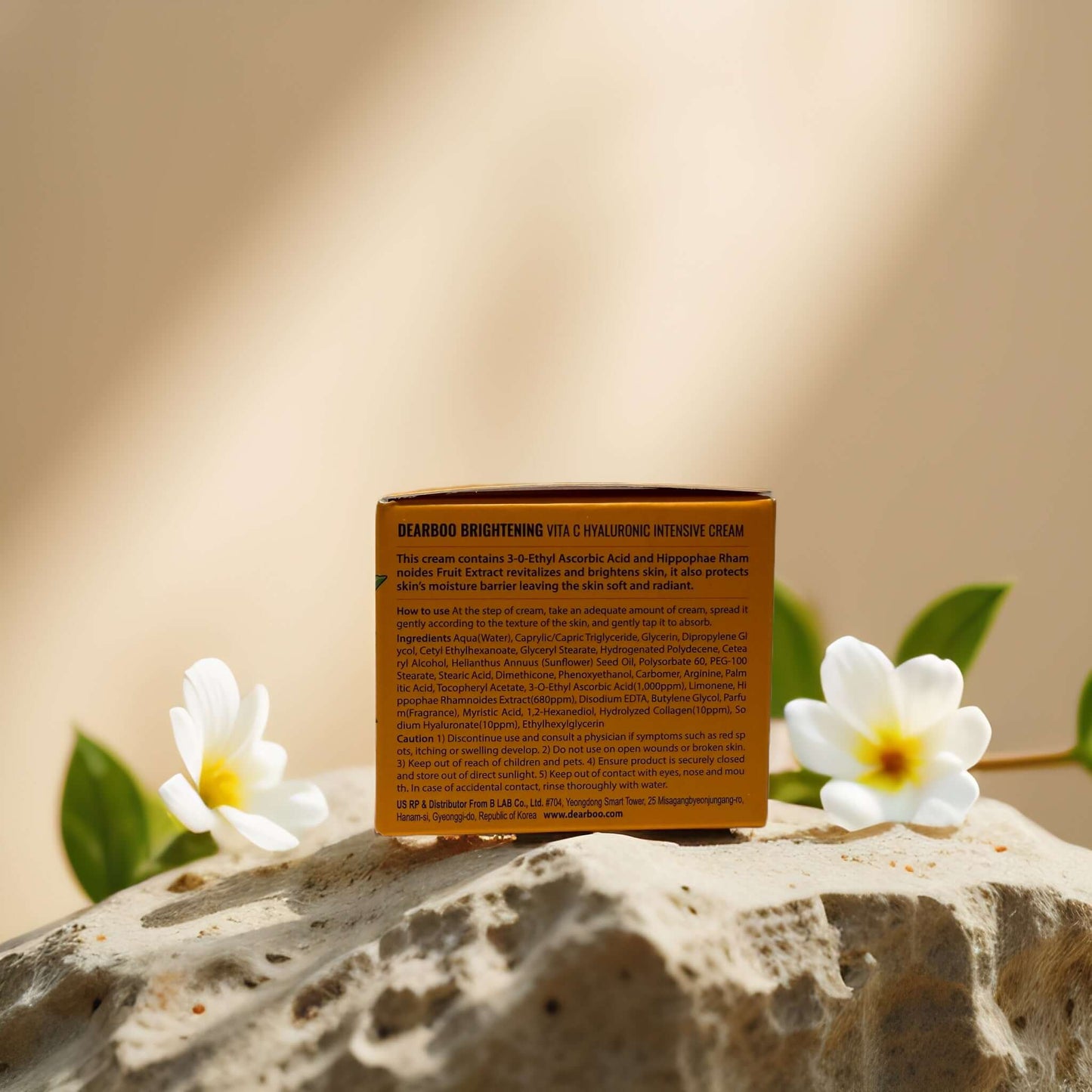 Dearboo Brightening Face Cream with Vitamin C and Hyaluronic Acid, displayed with flowers on a stone background.