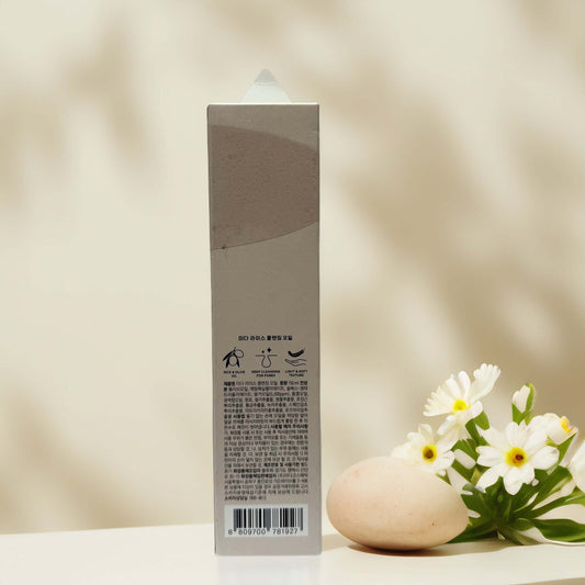 Back view of MIDHA Rice Cleansing Oil packaging with flowers.