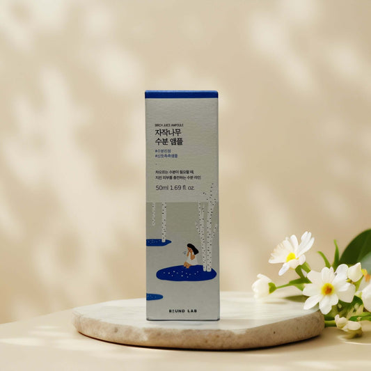 Round Lab Birch Juice Ampoule packaging on a stone surface.