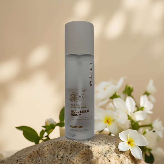 PRETTYSKIN Snail Multi Serum bottle on a stone with flowers, offering deep hydration and skin repair.