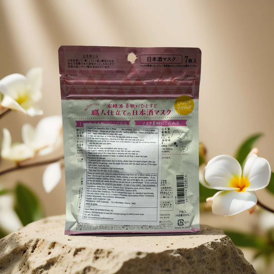 Bihada-Syokunin facial mask pack featuring sake extract for brightening and moisturizing skin, displayed on a stone with flowers.