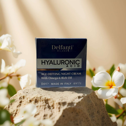 Delfanti Hyaluronic Acid Age-Defying Night Cream on a rock with flowers, 1.7 oz packaging.