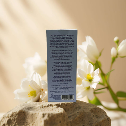 Back view of Dermabloom Firming Hydration Face Roller Cream showing ingredients and instructions on a stone background.