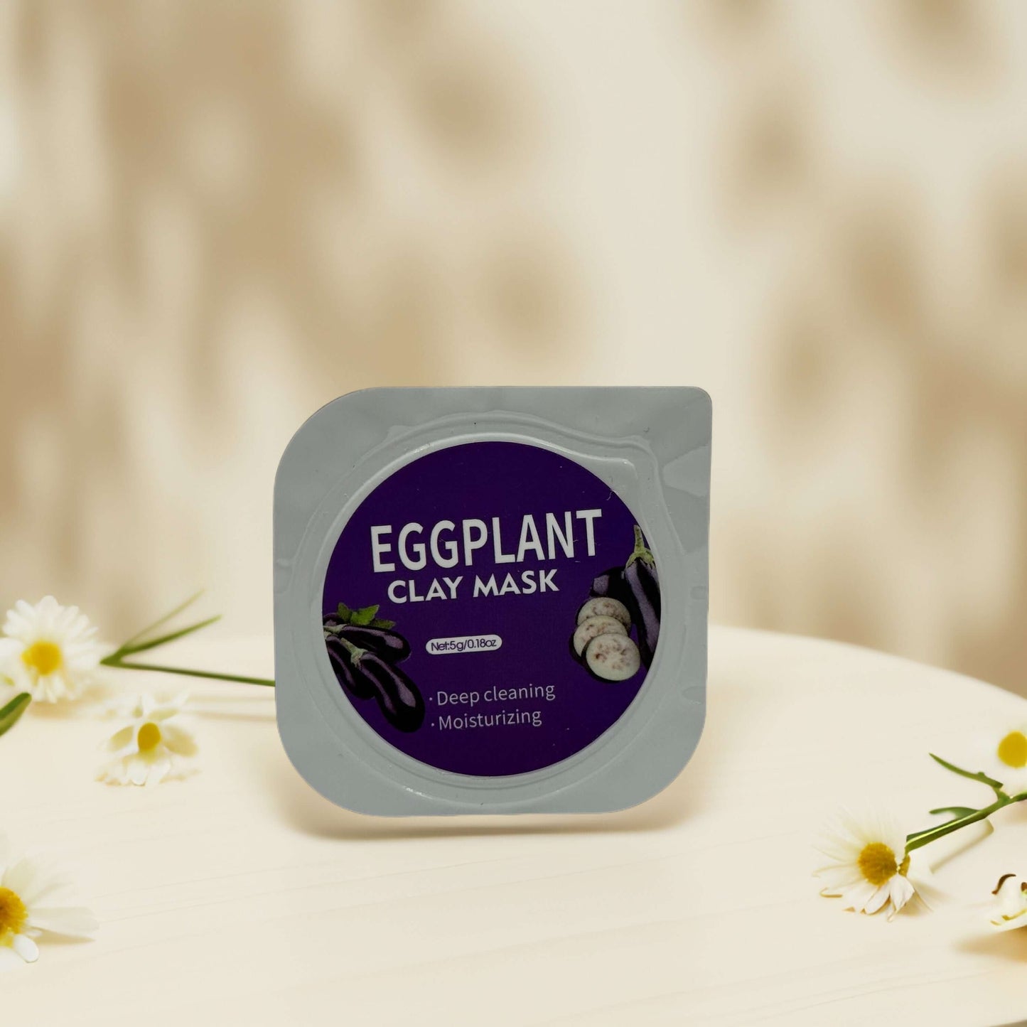 Eggplant clay mask pod for deep cleaning and moisturizing skin, displayed on a surface with flowers.