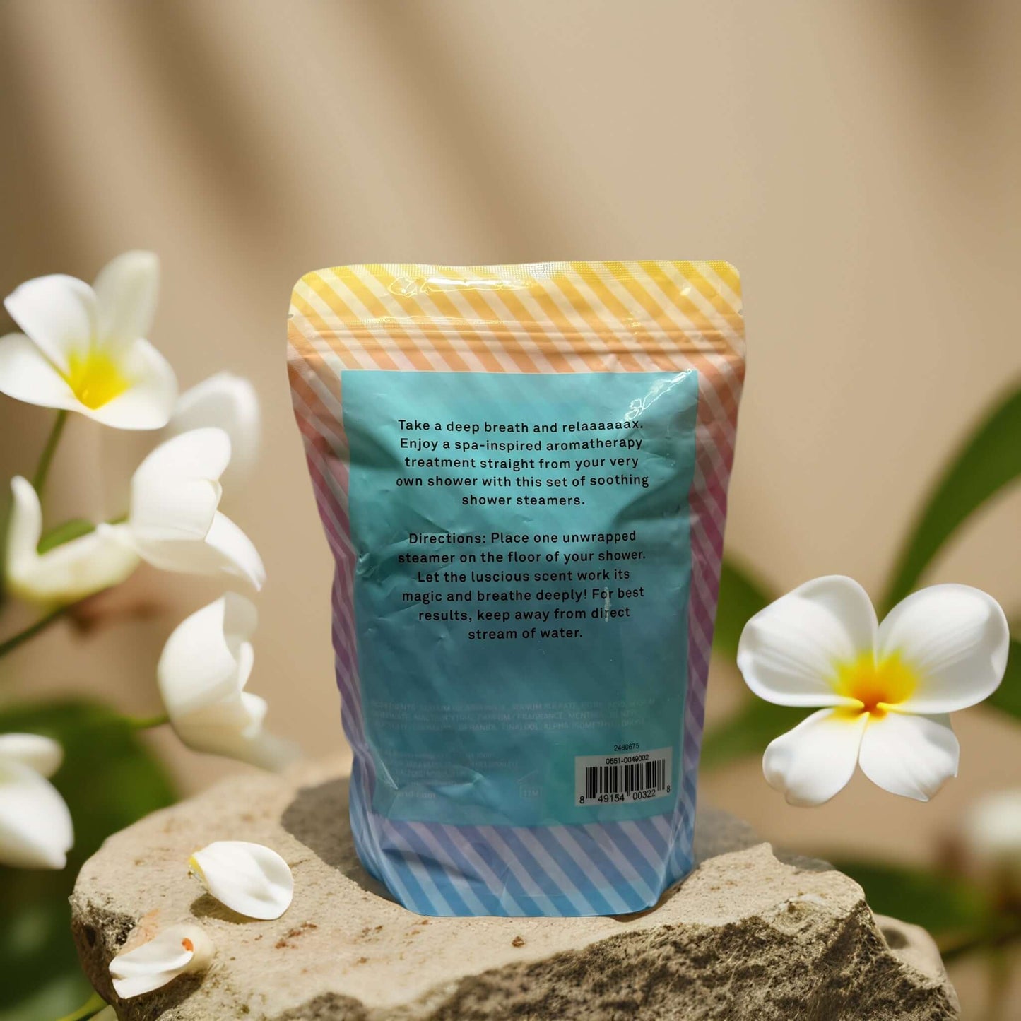 Energizing Eucalyptus Shower Steamers by Bliss in colorful packaging, surrounded by tropical flowers.