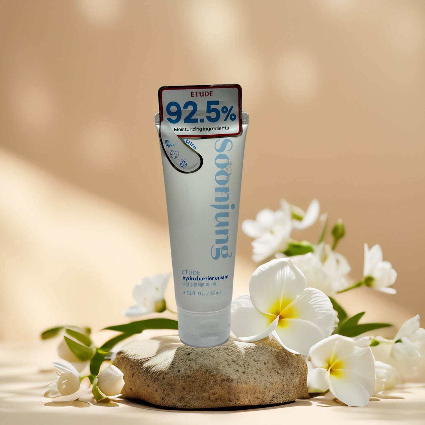 Hydro Barrier Cream by Etude with 92.5% moisturizing ingredients, surrounded by flowers on a stone.