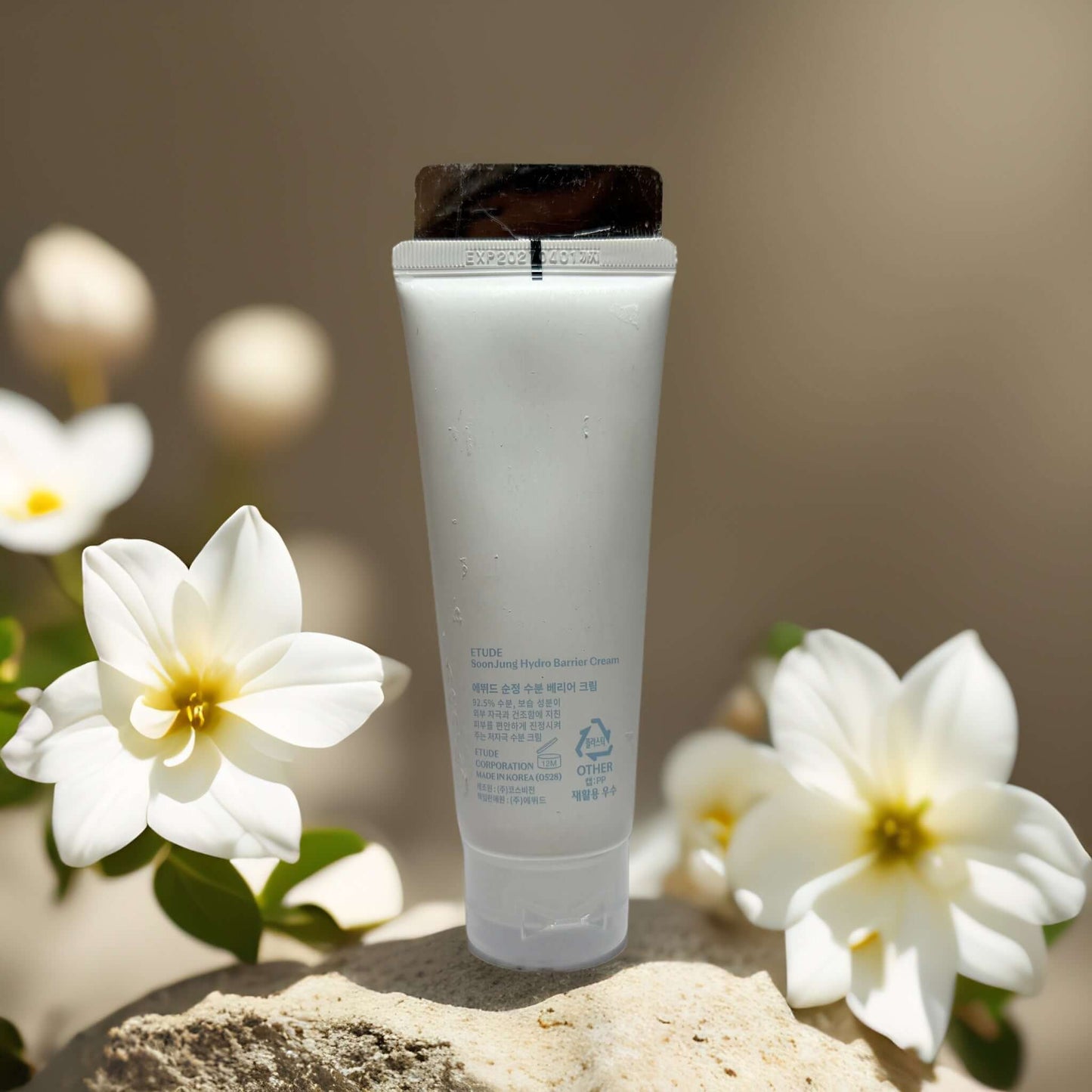 Etude Hydro Barrier Cream tube against a soft floral backdrop, showcasing hydration and barrier repair benefits.