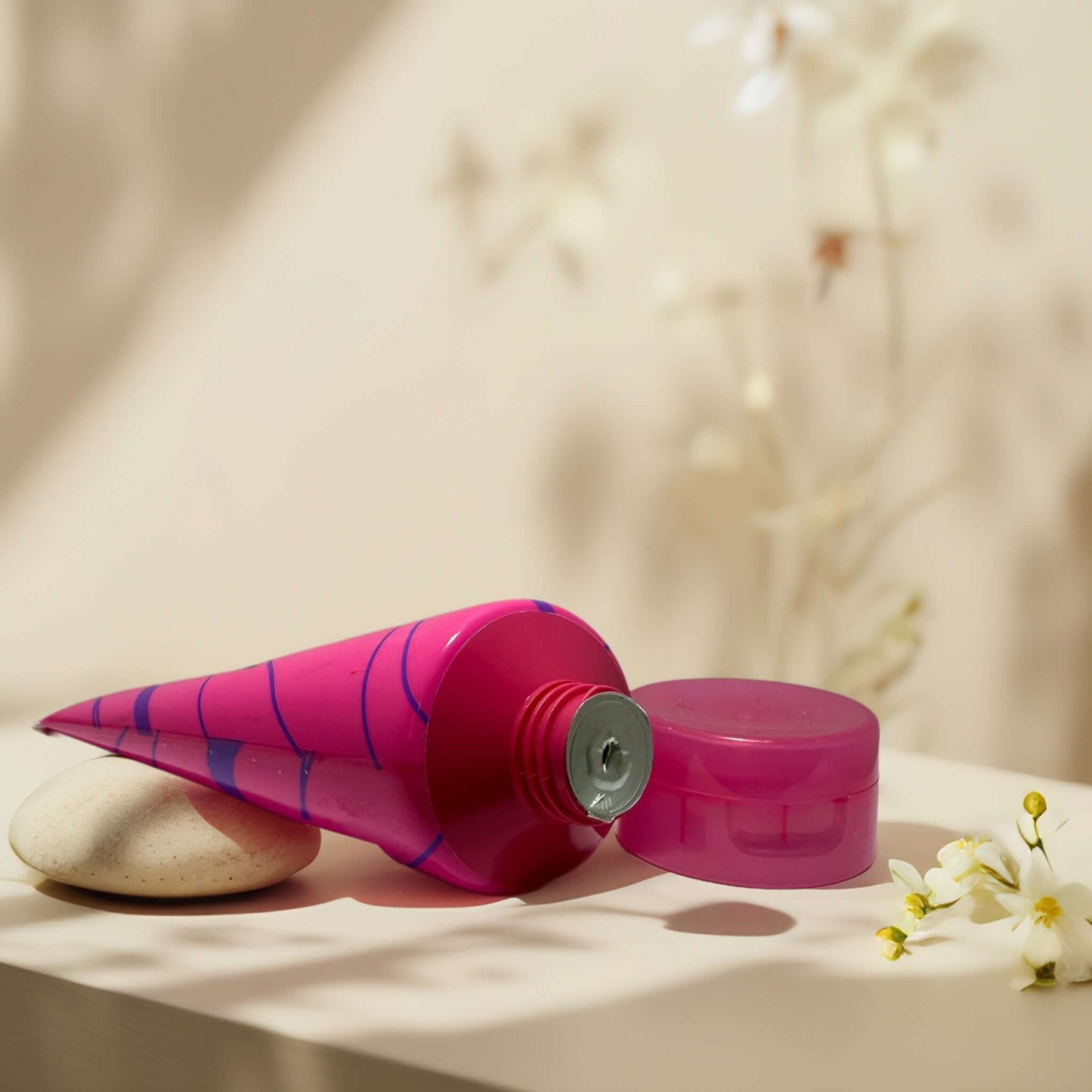 Glittering Nights Body Butter in vibrant pink tube with cap.
