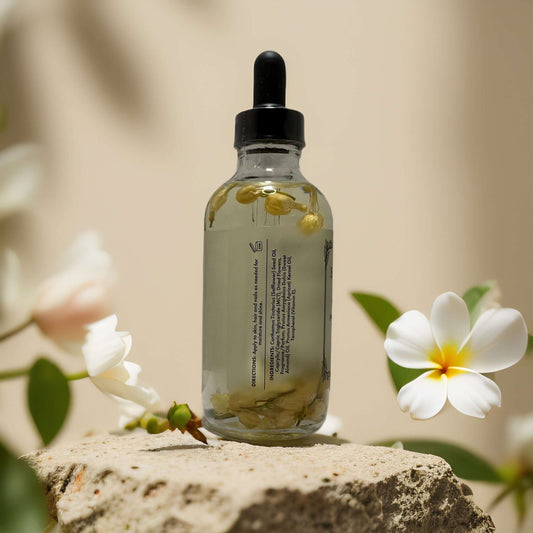 Glow & Nourish Honeysuckle Jasmine Multi-Use Oil in a glass dropper bottle with real flower petals inside.