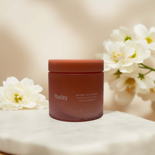 Huxley Conditioning Pad jar with floral backdrop, 4.7 fl oz.