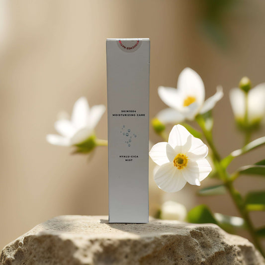 SKIN1004 Hydrating Barrier Mist product box surrounded by flowers, featuring centella asiatica and hyaluronic acid benefits.