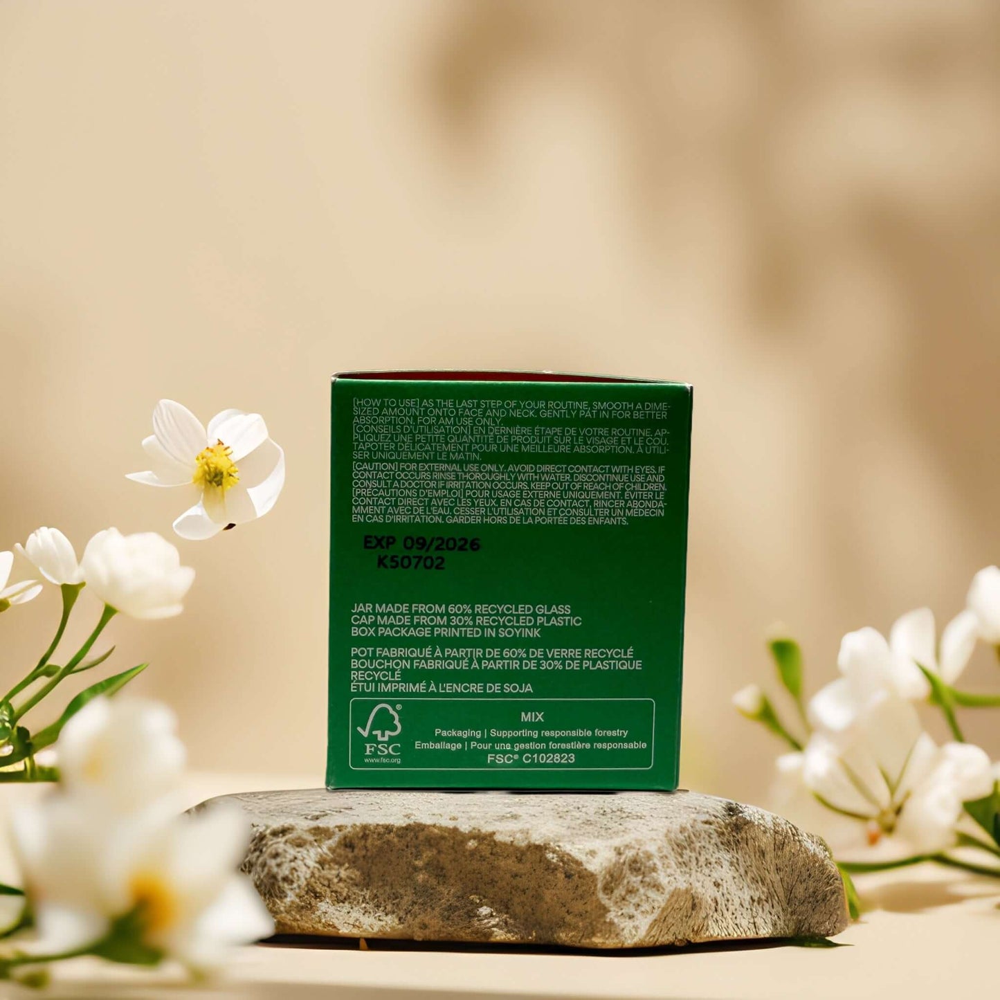 Back of Innisfree Glow Boosting Brightener box showing ingredients and expiration date, surrounded by flowers.