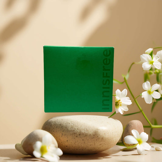 Innisfree Hydration & Balance Duo green tea hyaluronic skincare set on a neutral background with stones and flowers.