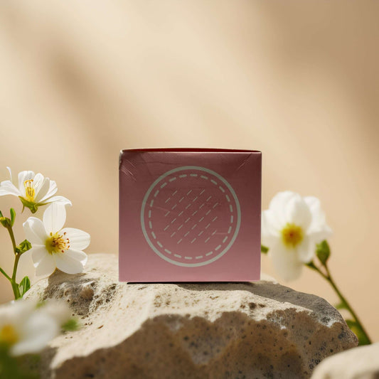 Collagen essence pads packaging by Maske Lab, surrounded by flowers on a stone surface.