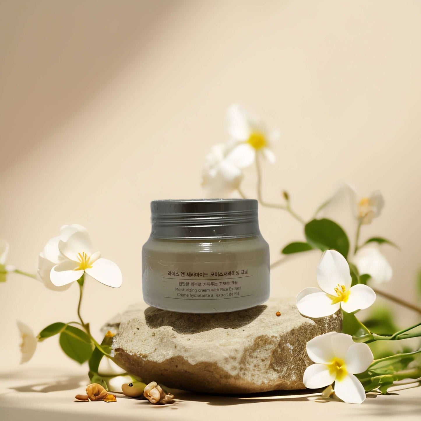 Moisture Barrier Support Rice Ceramide Cream on stone with flowers, 1.7 fl oz by The Face Shop.