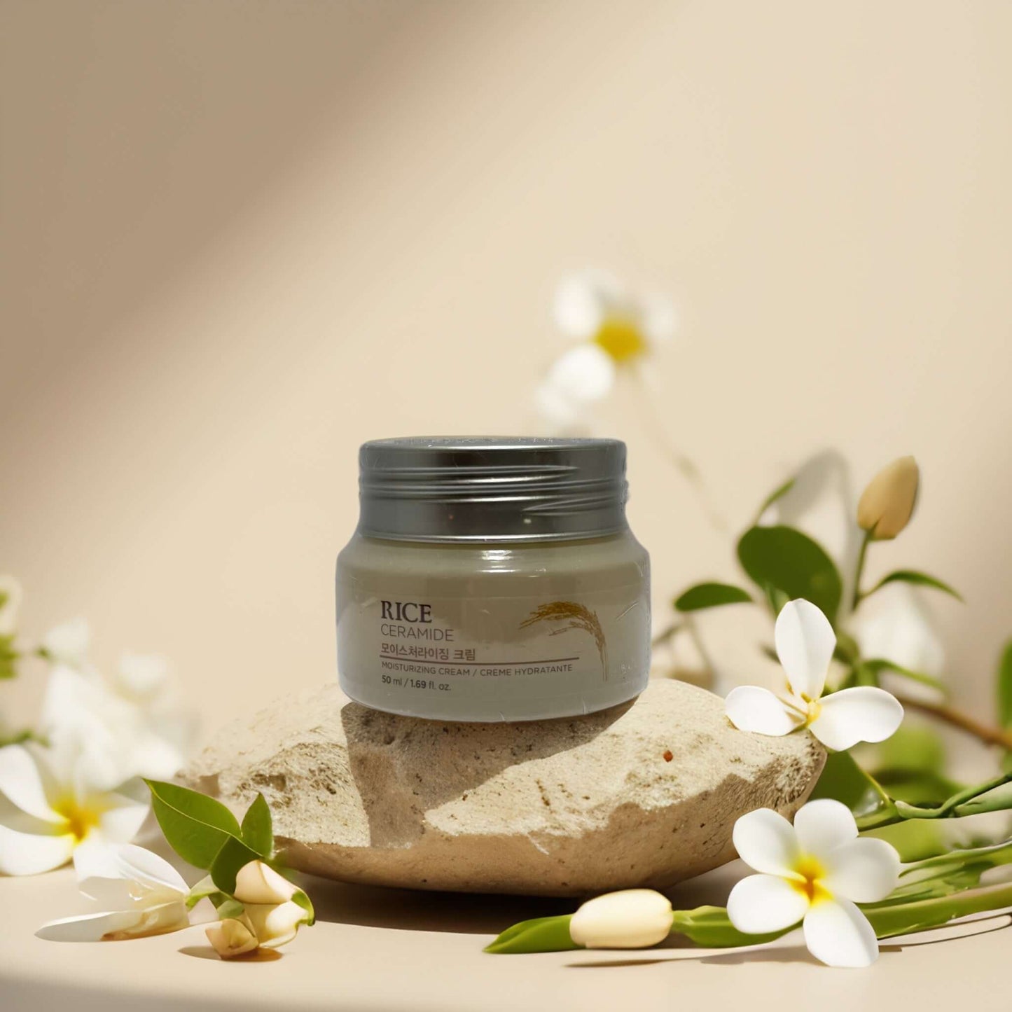 Moisture Barrier Support Rice Ceramide Cream by The Face Shop, 1.7 fl oz, with floral accents and natural stone.