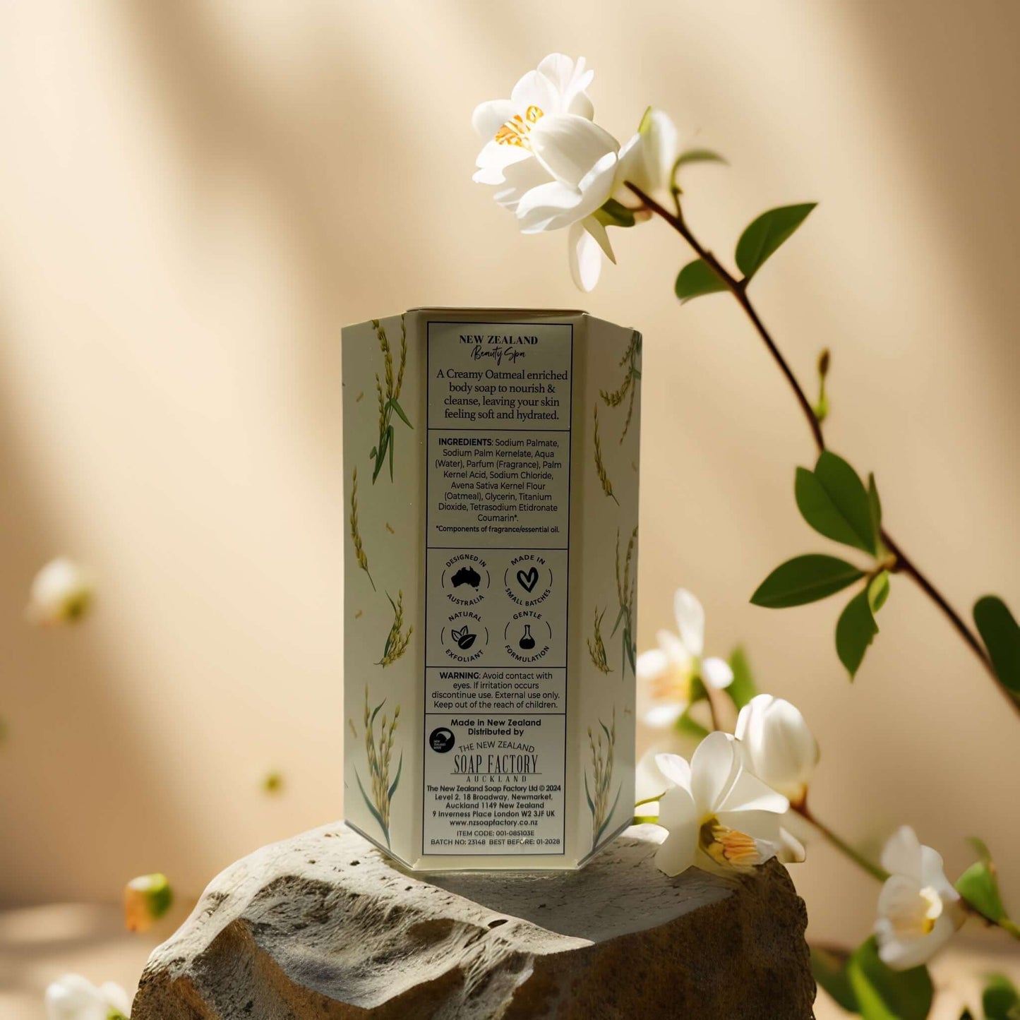 Back view of NZ Beauty Spa creamy oatmeal soap packaging with ingredient details on a stone surface.