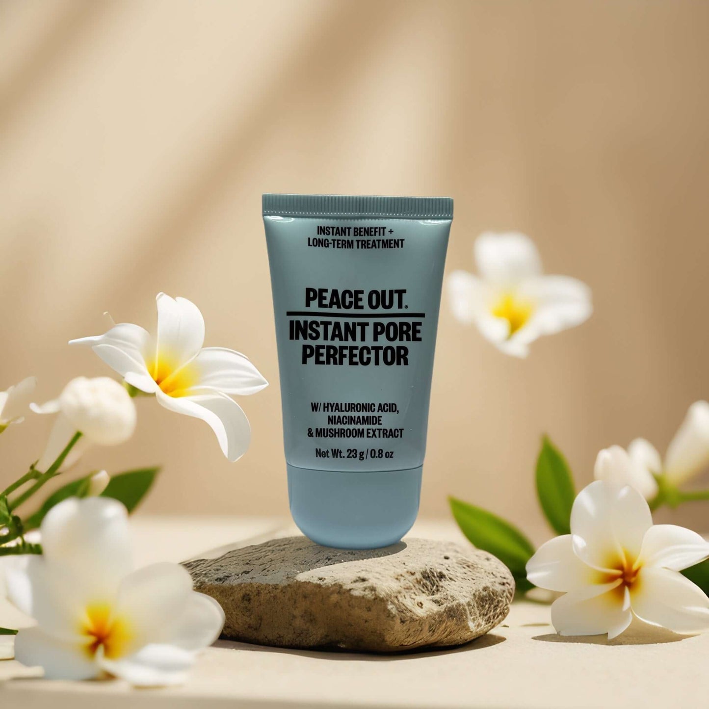 Peace Out Instant Pore Perfector tube on a textured surface with flowers, featuring hyaluronic acid and niacinamide.