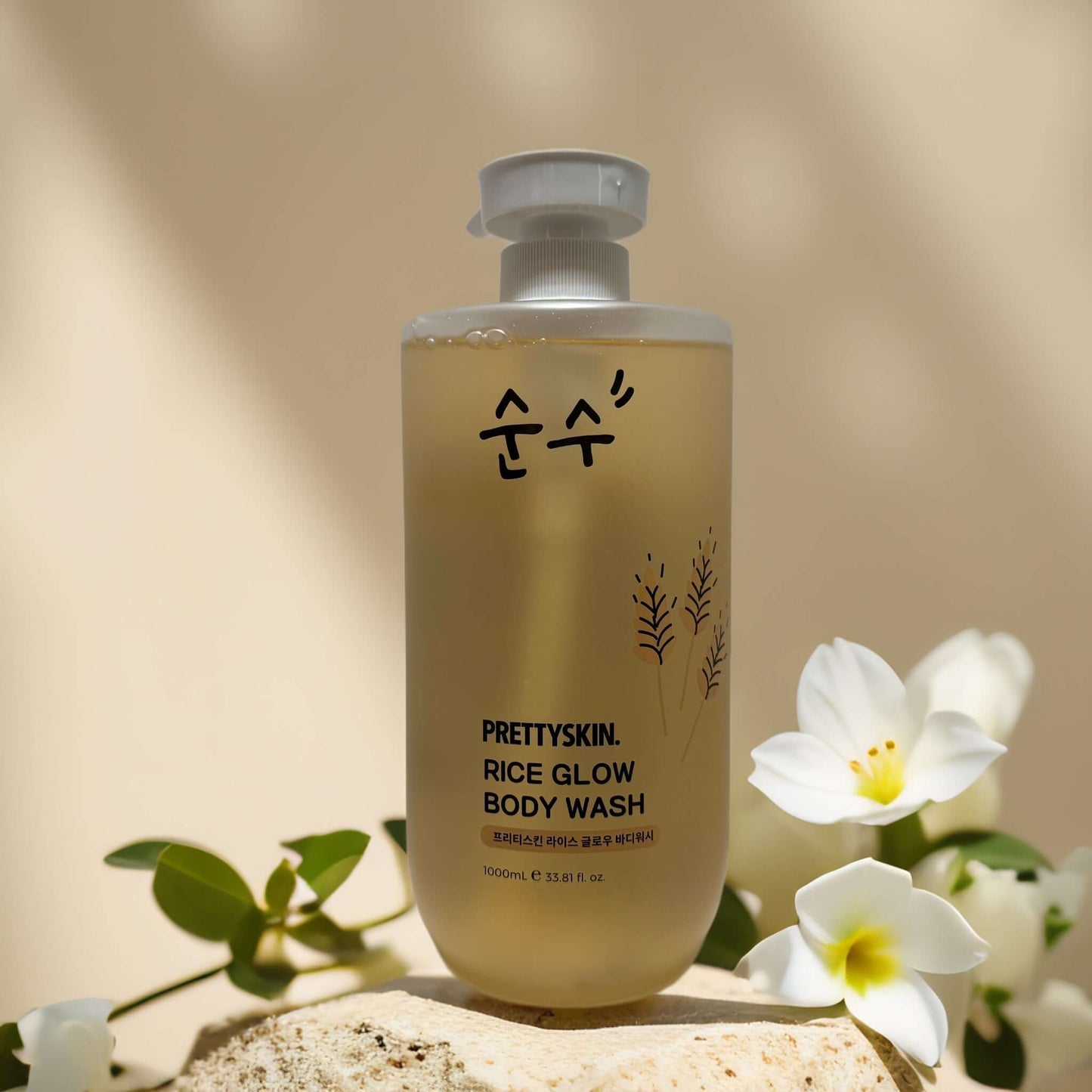 PRETTYSKIN Rice Glow Body Wash bottle with rice extract for brightening and hydrating skin, surrounded by white flowers.
