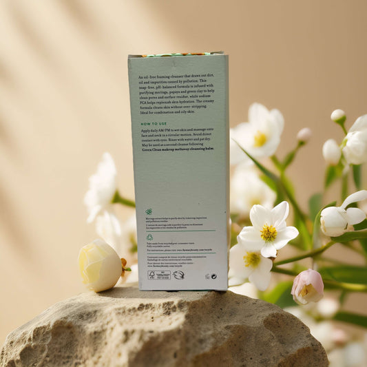 Back of Purifying & Balancing Whipped Greens Foaming Facial Cleanser packaging with usage instructions and floral backdrop.