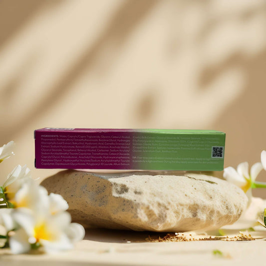 Purito Timeless Bloom Retinol Spot Cream packaging displaying ingredient list on a stone with flowers.