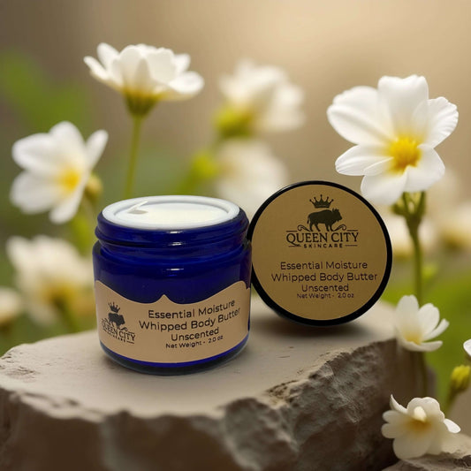 Queen City Skincare Unscented Whipped Body Butter in blue jar with flowers, 2 oz for hydration.