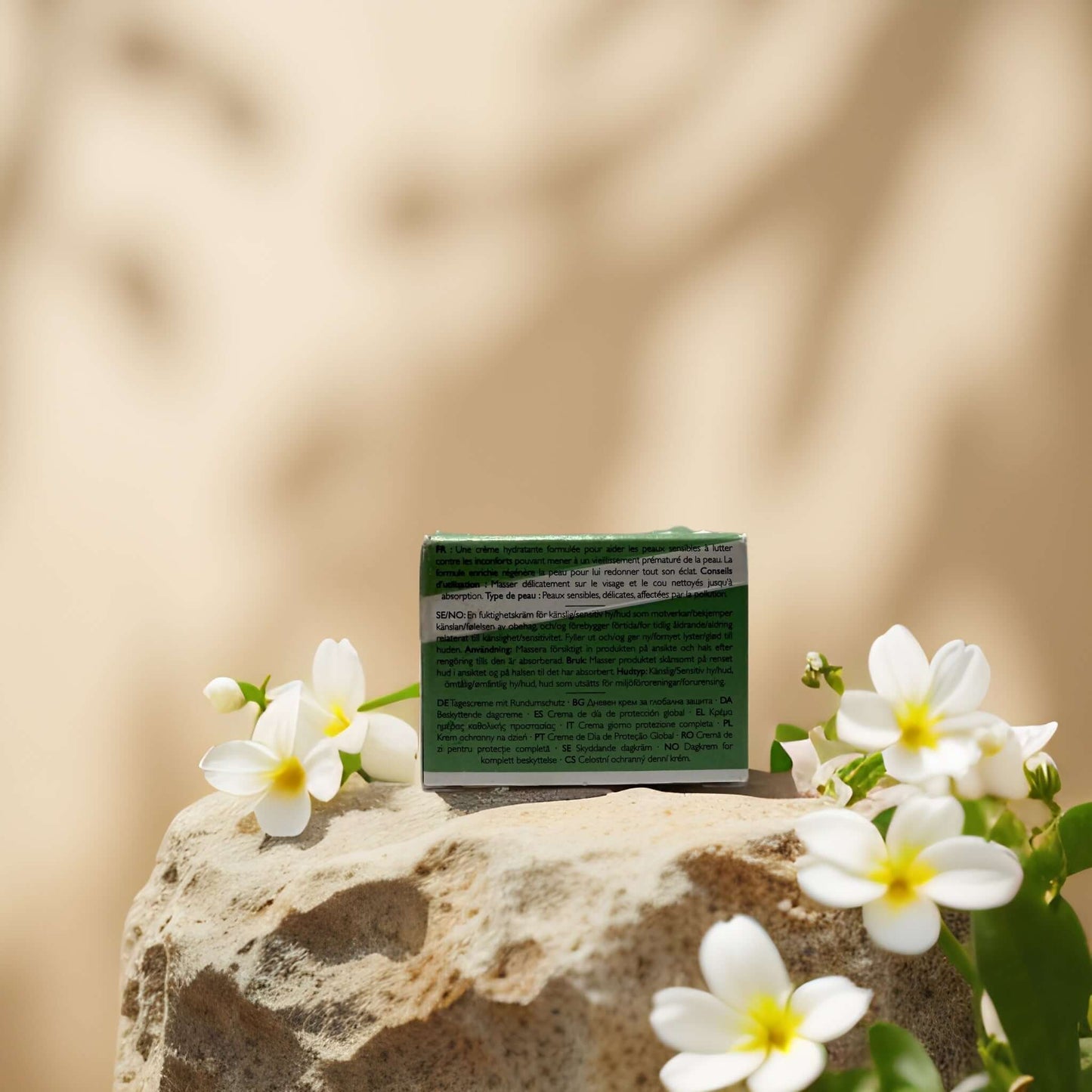 Calming & Barrier Repair Day Cream packaging surrounded by white flowers on a stone background, emphasizing natural skincare.
