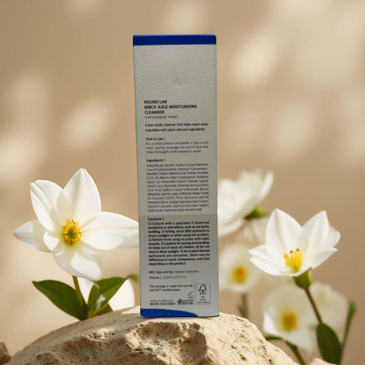 Back view of Round Lab Birch Juice Facial Cleanser, showcasing ingredients and details against floral backdrop.