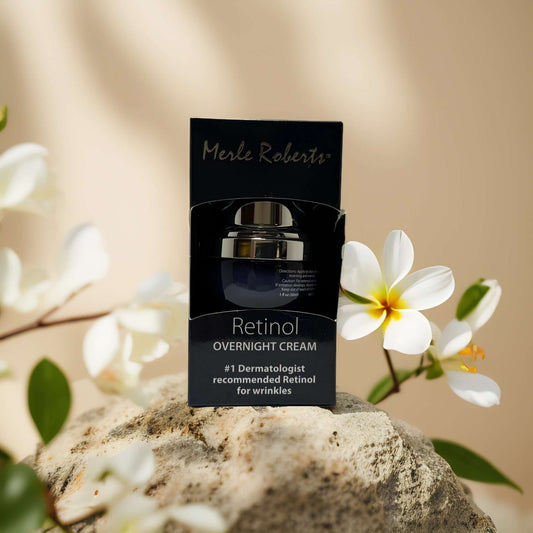Merle Roberts Retinol Overnight Cream packaging on a stone surface with flowers, designed for wrinkle care and hydration.