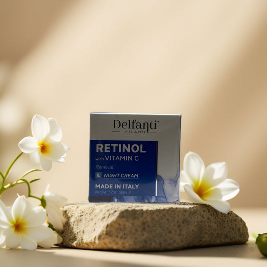Delfanti retinol night cream with vitamin C in a box on a stone, surrounded by white flowers.