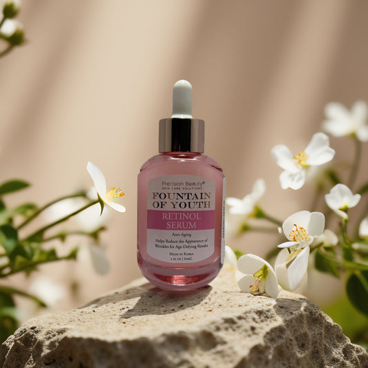 Precision Beauty Fountain of Youth Retinol Serum on a stone with white flowers, promoting youthful, radiant skin.